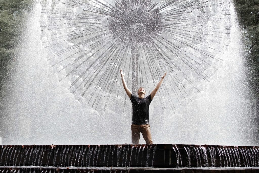 Senior guy standing in a fountain - Minneapolis