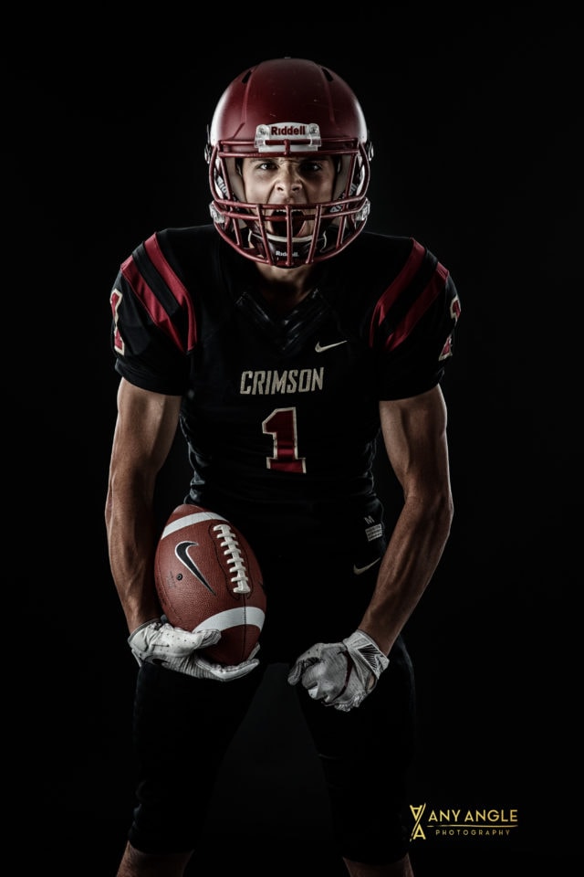 Senior guy pictures of football player in studio with dark background