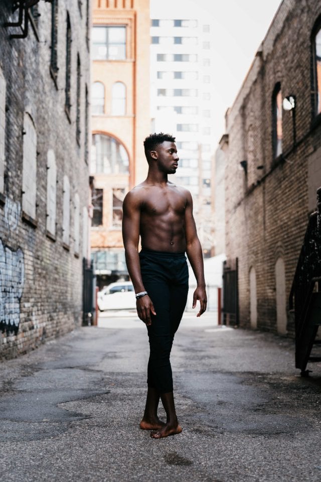 Black dancer in downtown alley.