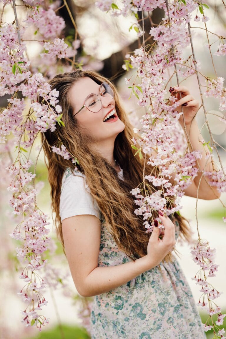Senior pictures with girl in Utah spring blossoms. Captured by Any Angle Photography.