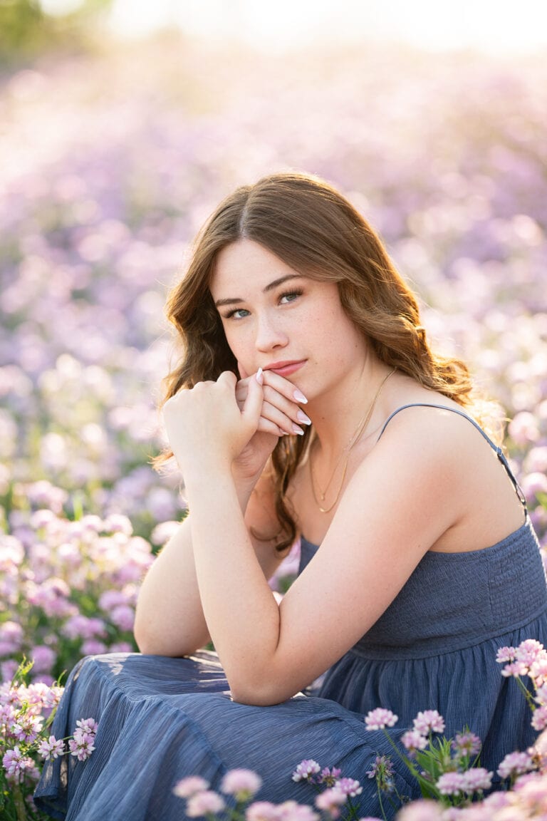 Nature senior pictures with girl sitting in purple flower field in Minneapolis. Captured by Minnesota senior photographer Any Angle Photography.
